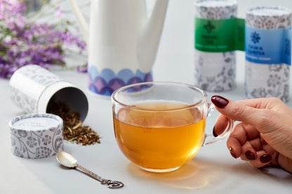 Loose leaf Calm and Claritea steeping in glass cup showing herbal infusion for stress relief
