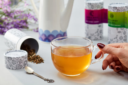 Loose leaf Mind and Body Day Tea steeping in ceramic mug showing amber herbal infusion
